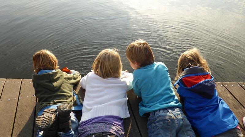 Kinder liegend auf Steg am See.jpg